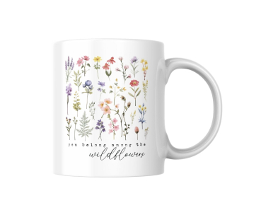 Weiße Keramiktasse mit filigranem Wildblumenmotiv und dem Zitat „You belong among the wildflowers“ auf neutralem Hintergrund.